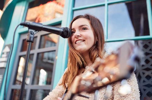 female-musician-busking-playing-acoustic-guitar-QGPZ2UP.jpg